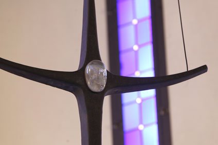 Kreuz in der Kapelle im St. Albertus Altenheim vor lilafarbenem Buntglasfenster
